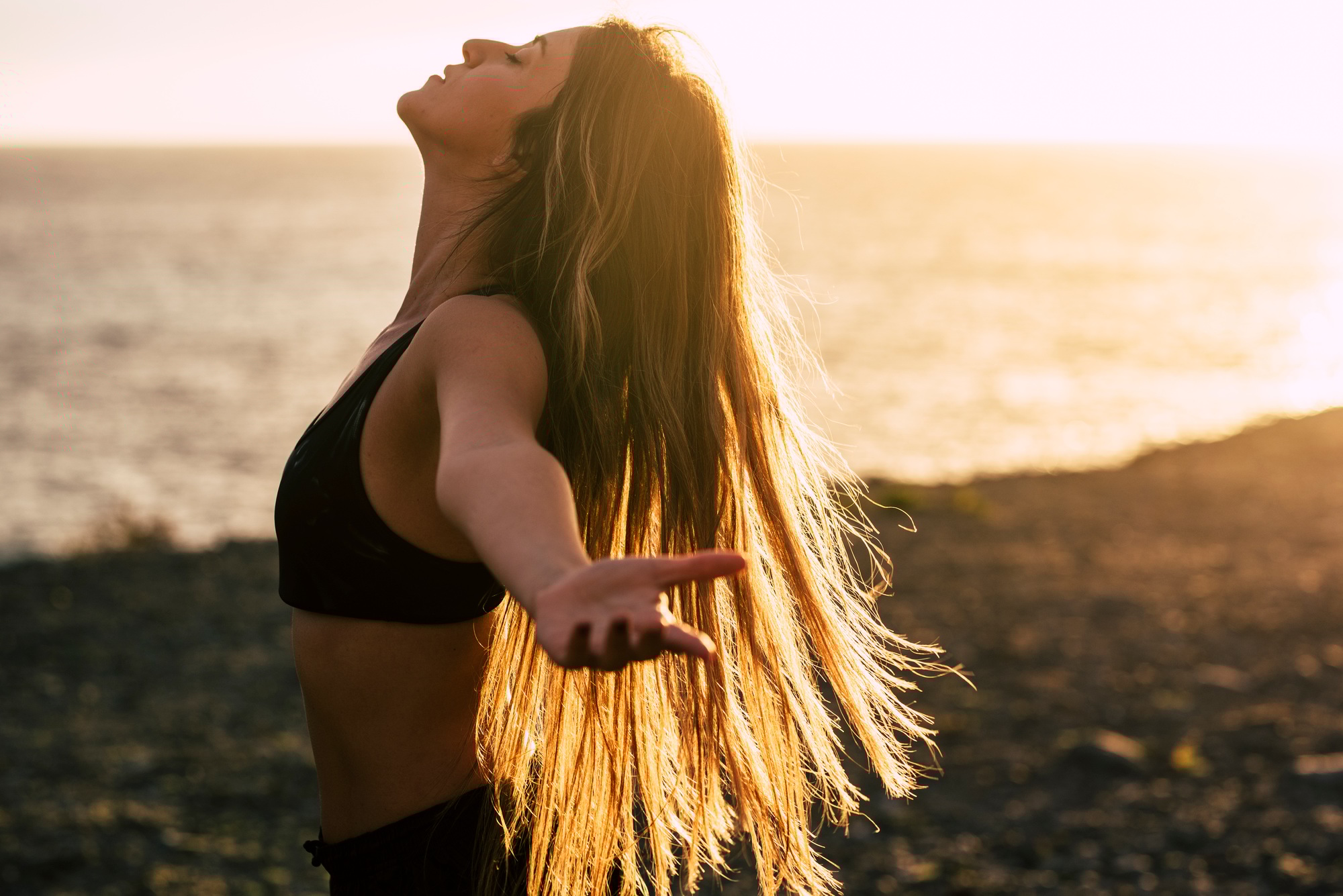 Sport and healthy people lifestyle concept. Side view of beautiful young woman opening arms and