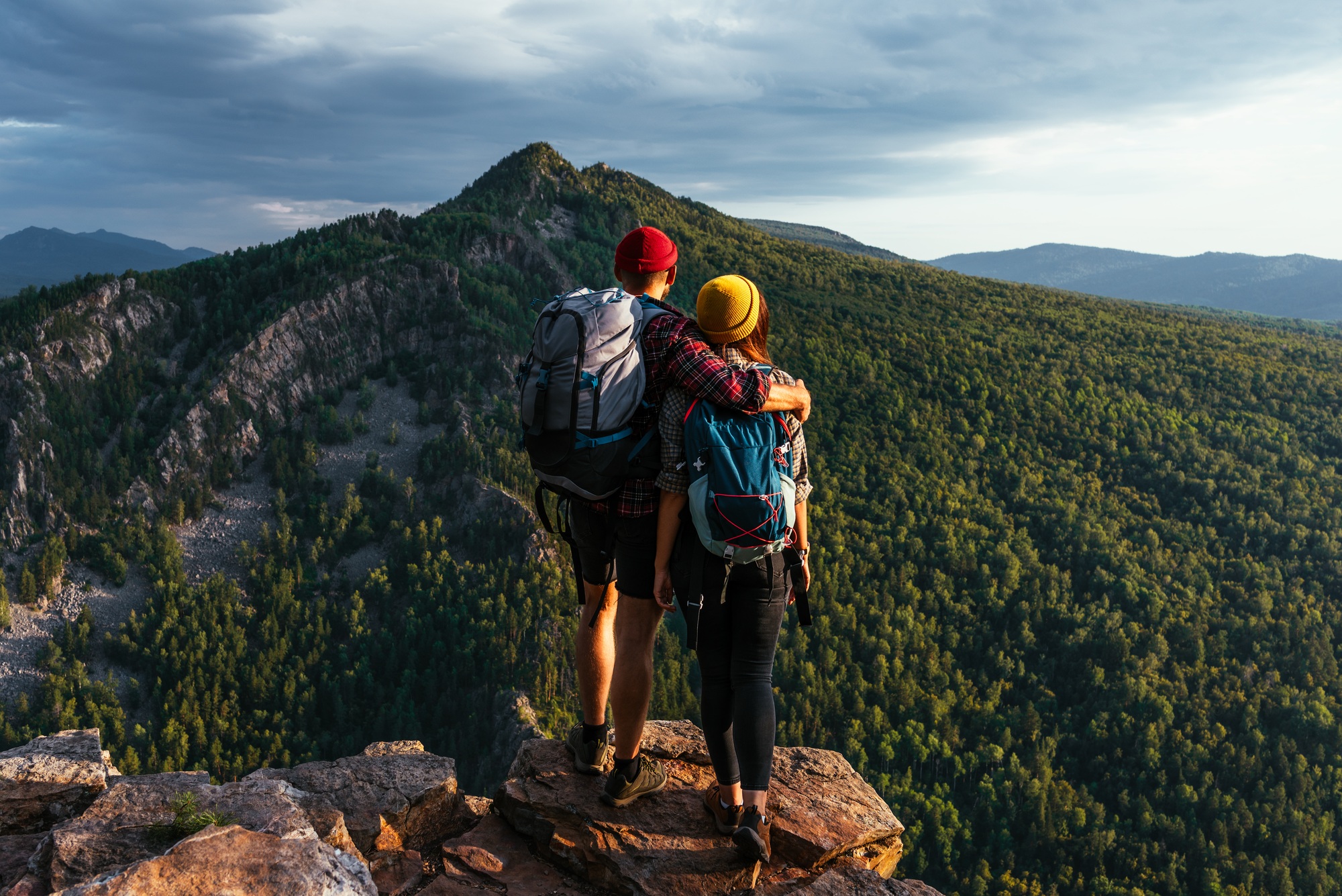 A happy couple in the mountains admires the beautiful views