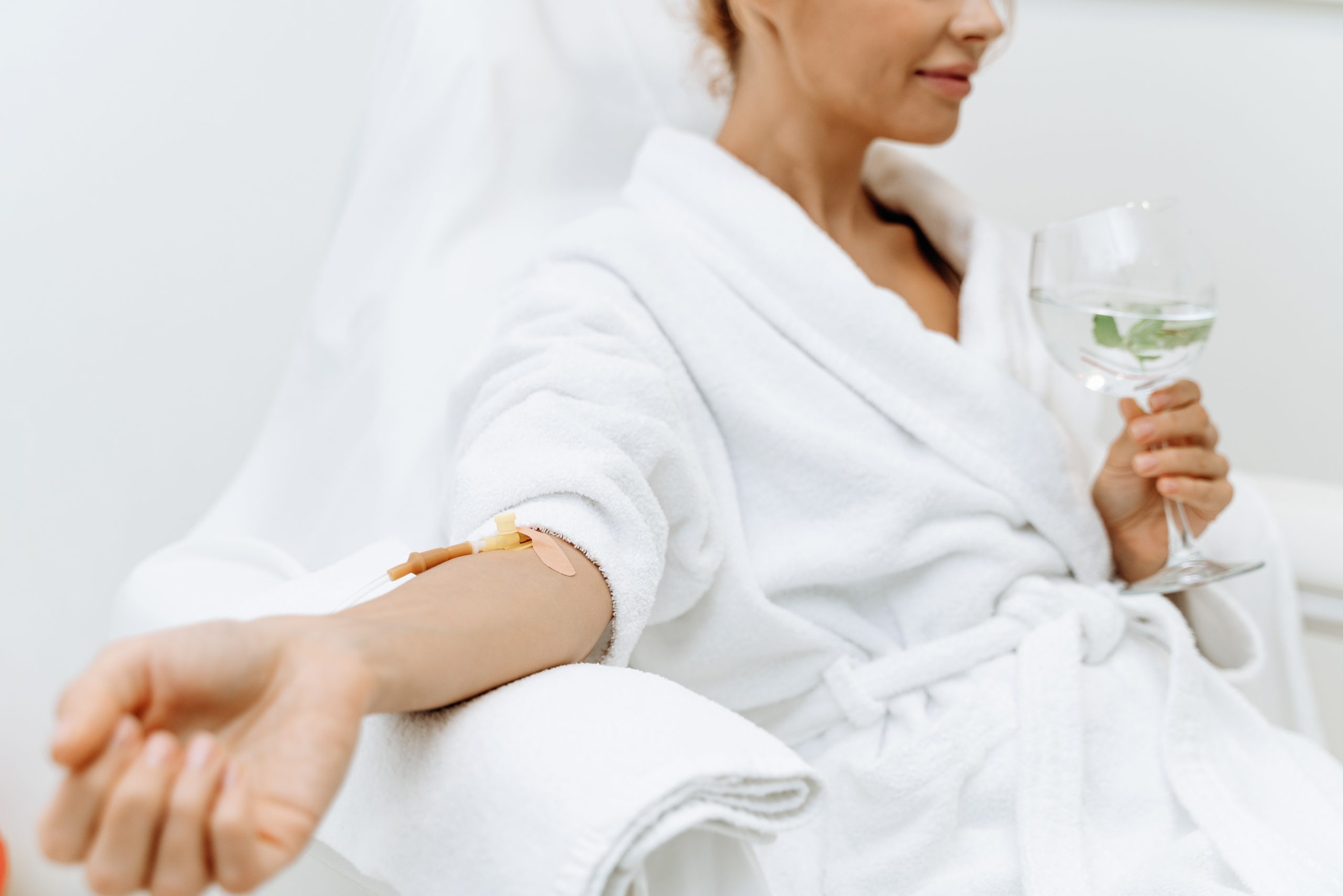 woman receiving iv drip while relaxing