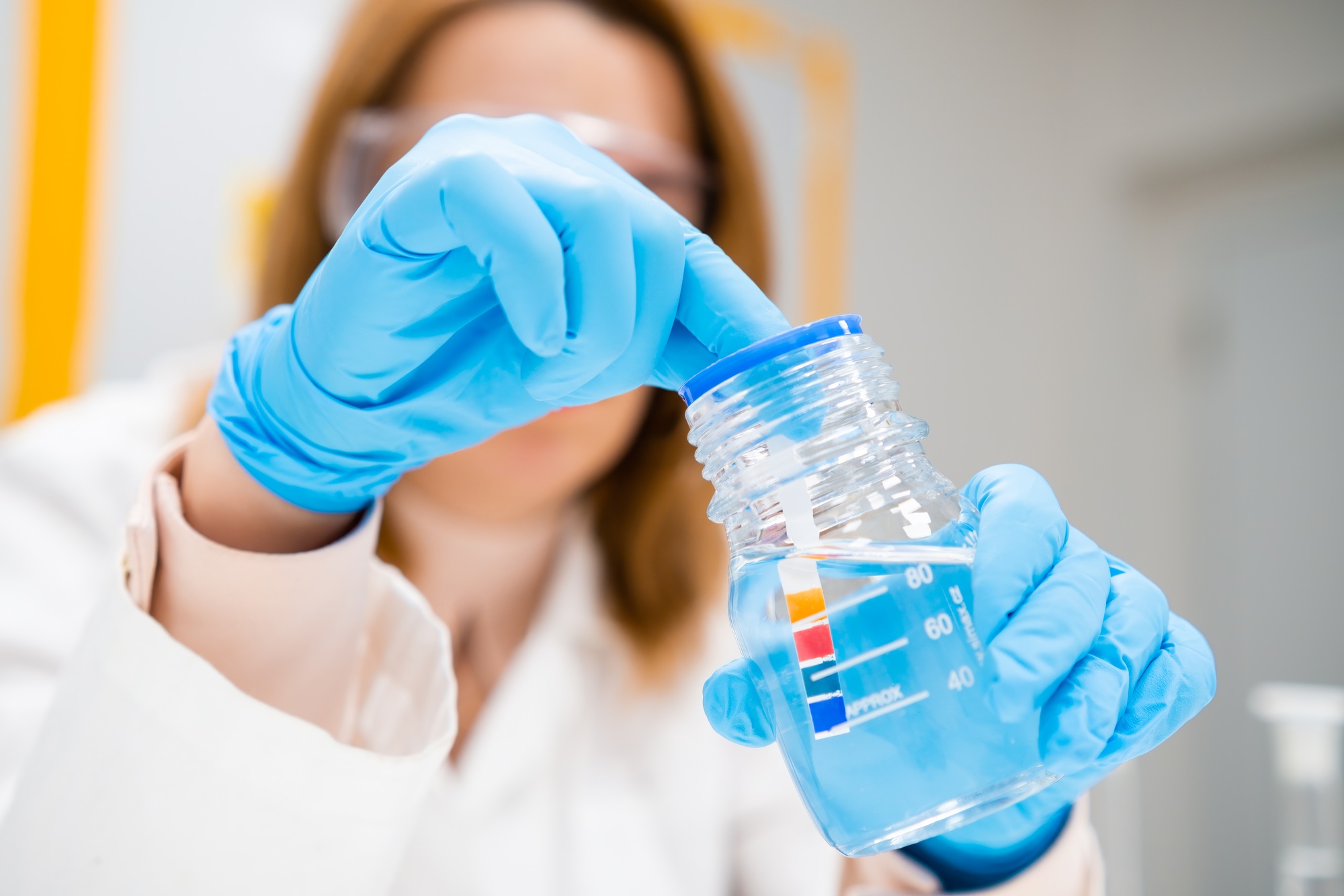 Scientist inserts a indicator paper into the solution, measurement of pH
