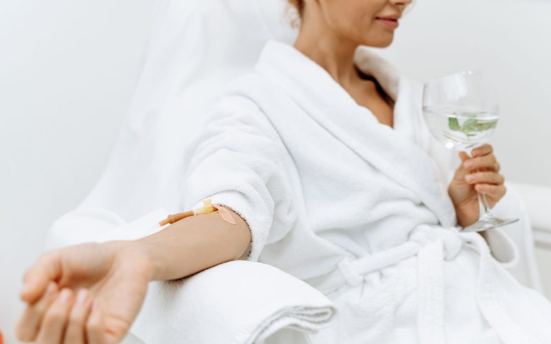woman receiving iv drip while relaxing
